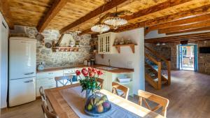 eine Küche mit einem Tisch und einer Blumenvase darauf in der Unterkunft Villa Lusa in Bajčići