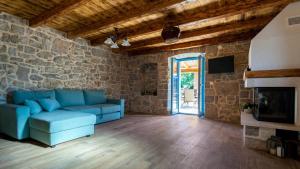 ein Wohnzimmer mit einem blauen Sofa und einer Steinmauer in der Unterkunft Villa Lusa in Bajčići