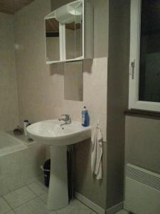 a bathroom with a white sink and a bath tub at Gîte Tucolet in Hinx