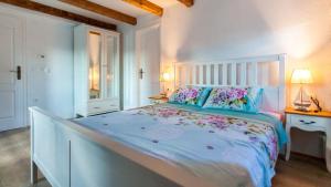 una camera bianca con un grande letto fiorito di Villa Lusa by Villas Holiday a Bajčići Altre 32 foto