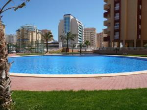 une grande piscine bleue avec des bâtiments en arrière-plan dans l'établissement Los Miradores, La Manga del Mar Menor, à Murcie
