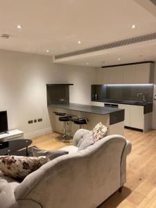 sala de estar con sofá y cocina en Studio come 1 Bed flat in Vauxhall next to Battersea, en Londres