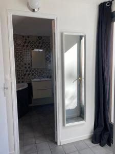 La salle de bains est pourvue d'un miroir et d'un lavabo. dans l'établissement Grand studio de 38m2 et cour indépendante de 25m2 dont wifi et Netflix, à Montpellier