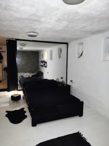 a living room with a black couch and a mirror at Artemis Studio Pyrgi in Mikonos