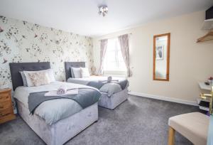 a bedroom with two beds and a mirror at Horse and Hound Country Inn in Bonchester Bridge