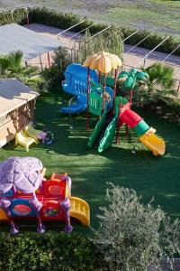 a playground with different colored slides and an umbrella at Golden Apartments in Marina di Cecina