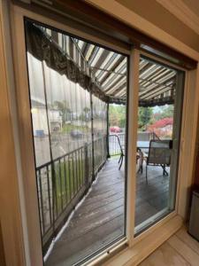 una puerta corredera de cristal que da a un porche con terraza en Sweetwater House en Quebec