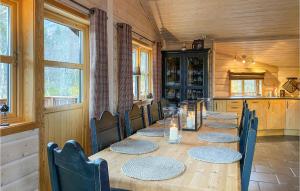 a dining room with a long table and chairs at Nice Home In Straumgjerde With Wifi in Brunstad