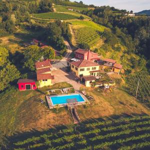 uma vista aérea de uma casa numa colina com uma piscina em Agriturismo Tenuta MonteOliveto - Classic Cottage XL em Vesime