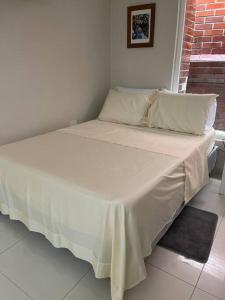 ein großes Bett mit einer weißen Tagesdecke darauf in der Unterkunft 306Hermoso, céntrico y acogedor loft en Cartagena in Cartagena de Indias + 6 Fotos