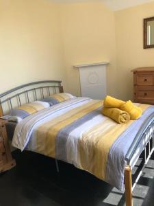 a bedroom with a large bed with yellow pillows at Frog Firle View in Alfriston