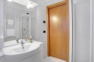 a bathroom with a sink and a wooden door at Bricola Biennale Apartments in Venice