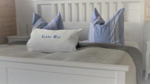 a white bed with a pillow with the words little hrs at Haus Weitblick in Glückstadt