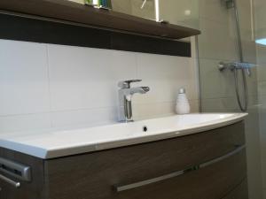 lavabo blanco en el baño con espejo en Haus Weitblick, en Glückstadt