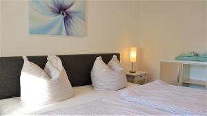 a bedroom with a bed with white pillows on it at Haus Weitblick in Glückstadt