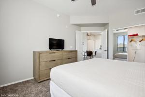 1 dormitorio con cama y vestidor con TV en Ascent North Scottsdale Pool Gym Apartments Near Mayo and Scottsdale Quarter en Scottsdale