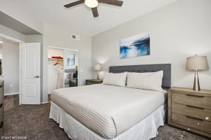 a bedroom with a white bed and a ceiling fan at Ascent North Scottsdale Pool Gym Apartments Near Mayo and Scottsdale Quarter in Scottsdale