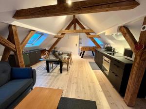 uma cozinha e sala de estar com vigas de madeira em Le passage des cinq - 5 min du tram 15 min Strasbourg centre em Eckbolsheim