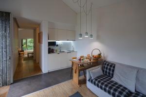 a living room with a couch and a table and a kitchen at Sete Cidades Lake Lodge in Sete Cidades