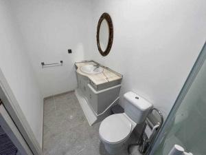 uma casa de banho com um WC branco e um lavatório. em Apartamento A em Irijoa