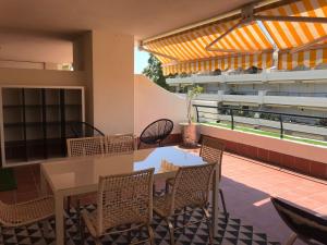patio con mesa y sillas en el balcón en Ático 2 Dormitorios en campo de Golf Guadalmina, Marbella, en Marbella