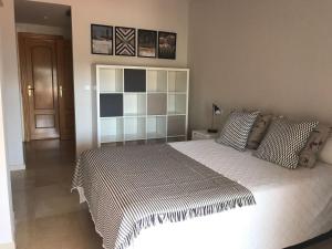1 dormitorio con 1 cama con edredón blanco y negro en Ático 2 Dormitorios en campo de Golf Guadalmina, Marbella, en Marbella