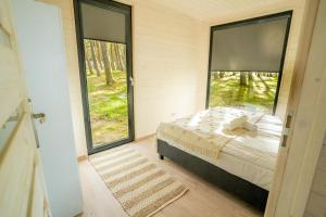 a bedroom with a bed and a large window at Ustronie Park - beach resort in Ustronie Morskie