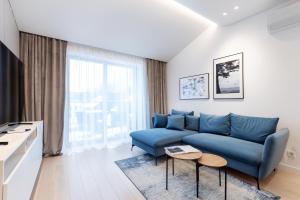 uma sala de estar com um sofá azul e uma mesa em #stayhere - Brand New & Ultra Modern 2BDR Upscale Neighbourhood Paupys em Vilnius