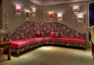 a large red couch in a room with flowers at Dryades Hotel in Naousa