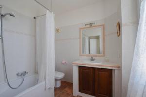 een badkamer met een wastafel, een toilet en een spiegel bij La Bastide de Villecroze in Villecroze