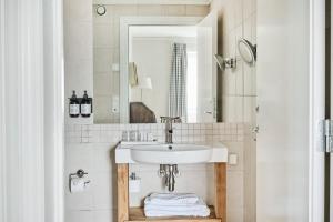 a bathroom with a sink and a mirror at Rederiet Hotel in Farsund