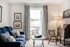 uma sala de estar com um sofá azul e uma mesa em Rederiet Hotel em Farsund