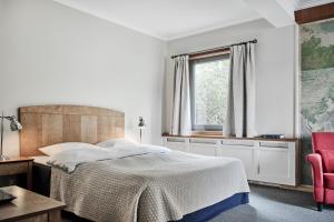 1 dormitorio con cama y ventana en Rederiet Hotel en Farsund