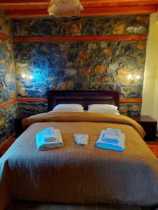 a bedroom with a bed with towels on it at Anesis Suites in Palaios Agios Athanasios
