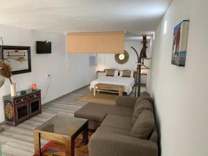 una sala de estar con un sofá y una cama en Little Paradise in El Médano 2, en Granadilla de Abona