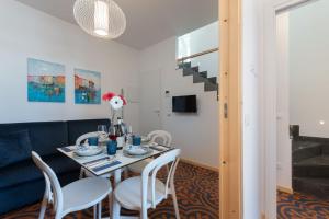 - une salle à manger avec une table, des chaises et un canapé dans l'établissement VOGLIA D'ESTATE apartments, à San Vito Lo Capo
