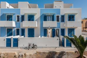 niebiesko-biały budynek z rowerem zaparkowanym przed budynkiem w obiekcie VOGLIA D'ESTATE apartments w mieście San Vito lo Capo