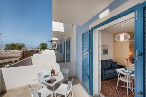 een kamer met een balkon met een tafel en stoelen bij VOGLIA D'ESTATE apartments in San Vito lo Capo