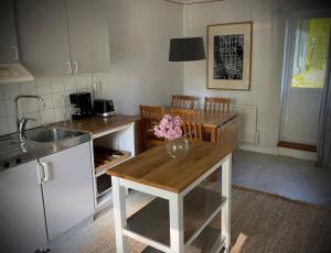 une cuisine avec une table et un vase de fleurs. dans l'établissement Gåsen Out, à Burgsvik