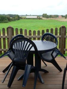 un tavolo nero e due sedie su una terrazza di Whg 4 - Ferien auf einem Resthof a Schönhagen