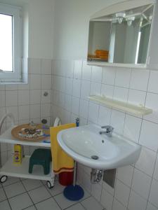 bagno bianco con lavandino e specchio di Whg 4 - Ferien auf einem Resthof a Schönhagen