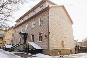 a large wooden building with snow on the ground at Central 1-bedroom Apartment with Bath & Balcony in Tallinn