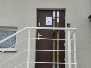 a door with a sign on it in front of a building at Apartament Chopina in Suwałki