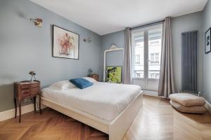 sypialnia z dużym łóżkiem i oknem w obiekcie Veeve - Time for Teak w Paryżu