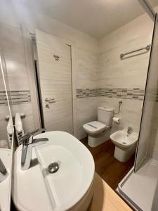 y baño con lavabo, aseo y ducha. en Hotel Villa Aurora, en San Martino di Castrozza