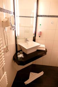 a bathroom with a sink and a mirror at Hotel O'felder in Osterrönfeld