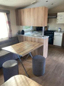 a kitchen with a table and two stools in a caravan at Märchencamping in Stuhr