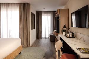 ein Hotelzimmer mit einem Bett und einem Schreibtisch. in der Unterkunft Strand Suites by NEU Collective in Gżira