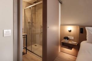 a bathroom with a shower and a bedroom with a bed at Strand Suites by NEU Collective in Il-Gżira