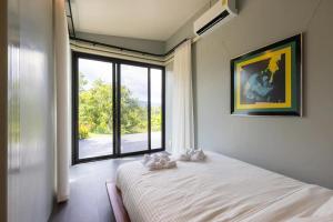 - une chambre avec un lit et une grande fenêtre dans l'établissement Stunning 3-Bed Villa in Chiang Mai, à Chiang Mai
